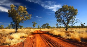 Une voiture roule sur une longue route rectiligne au cœur de l’outback australien.